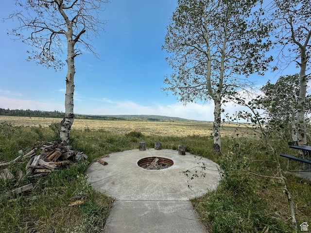 view of patio with a rural view and a fire pit