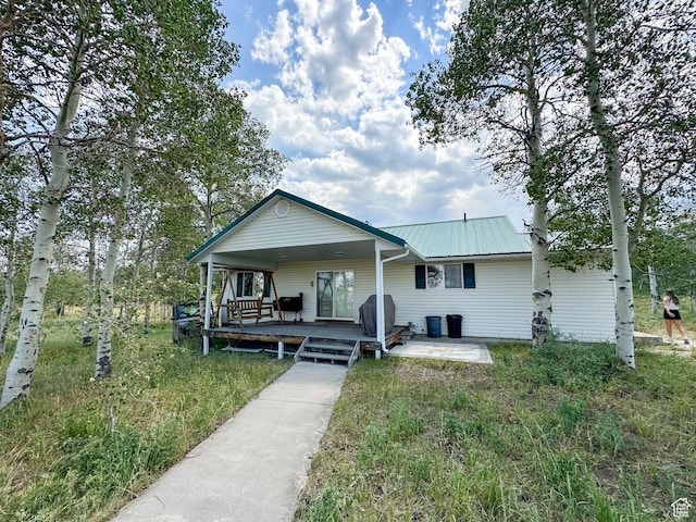 view of front of property with metal roof and a patio