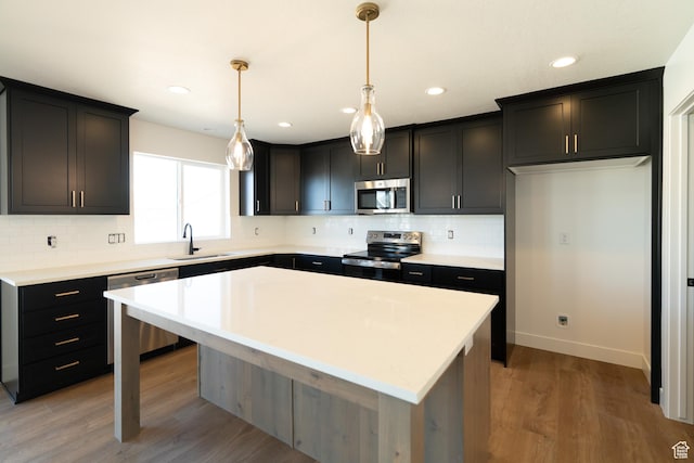 4111 N Ophir Dr, Eagle Mountain, UT 84005 - kitchen with stainless steel appliances, a sink, decorative backsplash, a center island, and recessed lighting