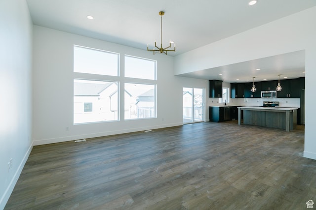 4111 N Ophir Dr, Eagle Mountain, UT 84005 - unfurnished living room featuring a chandelier, baseboards, dark wood finished floors, recessed lighting, and a sink