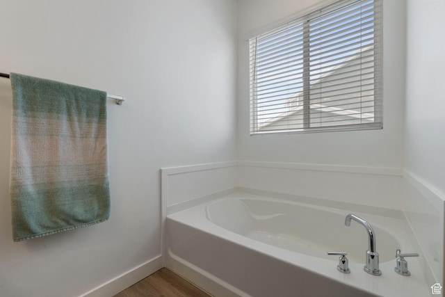 1033 E Bigelow Ave, Layton, UT 84040 - bathroom with a bath, wood finished floors, and baseboards