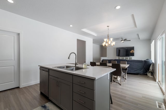 1033 E Bigelow Ave, Layton, UT 84040 - kitchen featuring gray cabinets, stainless steel dishwasher, light wood finished floors, a sink, and a raised ceiling