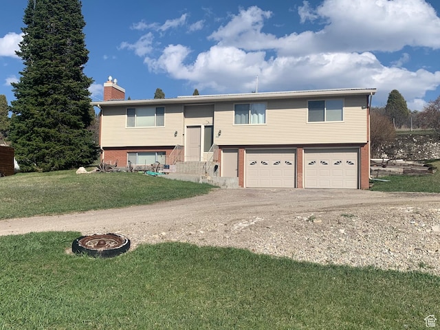 322 Bailey Rd, Soda Springs, ID 83276 - bi-level home featuring a garage, driveway, a chimney, brick siding, and entry steps