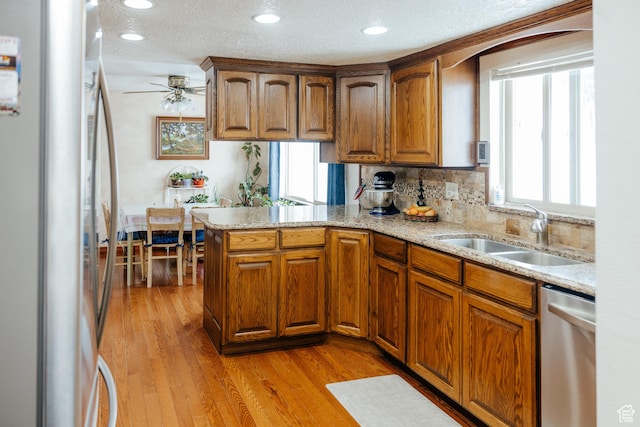 322 Bailey Rd, Soda Springs, ID 83276 - kitchen featuring stainless steel dishwasher, freestanding refrigerator, a sink, a peninsula, and brown cabinets