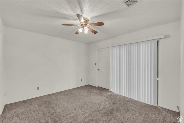 empty room featuring carpet flooring, a ceiling fan, and a textured ceiling