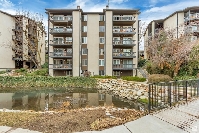 4953 S Eastridge Ln E Unit 143, Salt Lake City, UT 84117 - view of property with a water view, stairs, and fence