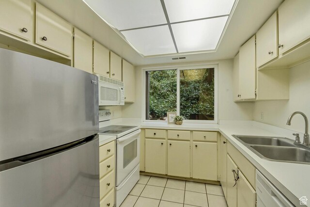 4953 S Eastridge Ln E Unit 143, Salt Lake City, UT 84117 - kitchen featuring light tile patterned floors, light countertops, cream cabinets, a sink, and white appliances