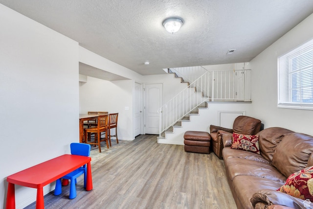 134 N 300 W, Spanish Fork, UT 84660 - living room with a textured ceiling, light wood-style flooring, visible vents, baseboards, and stairs