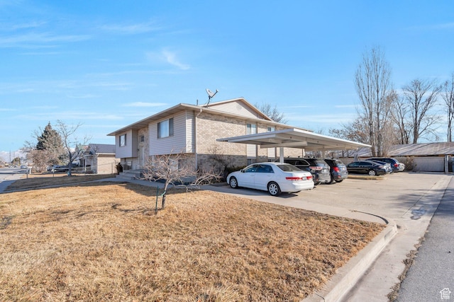 134 N 300 W, Spanish Fork, UT 84660 - view of home's exterior with covered and uncovered parking, a yard, and brick siding