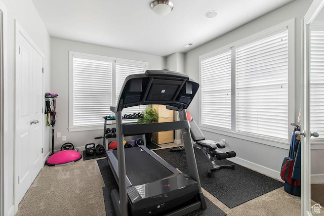 workout area featuring baseboards, carpet floors, and a healthy amount of sunlight
