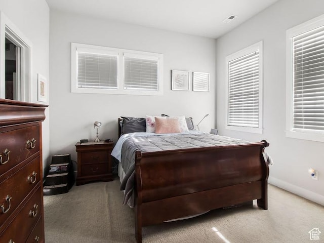 bedroom featuring baseboards and light colored carpet