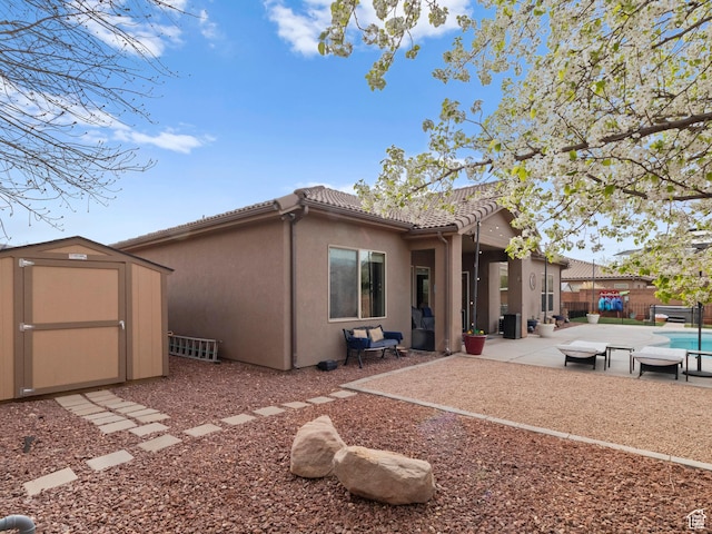 1908 S Yuma Dr, Washington, UT 84780 - rear view of house with a shed, a patio area, a fenced backyard, stucco siding, and a tile roof