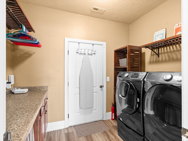 1908 S Yuma Dr, Washington, UT 84780 - laundry room with light wood-type flooring, washer and dryer, a textured ceiling, and cabinet space