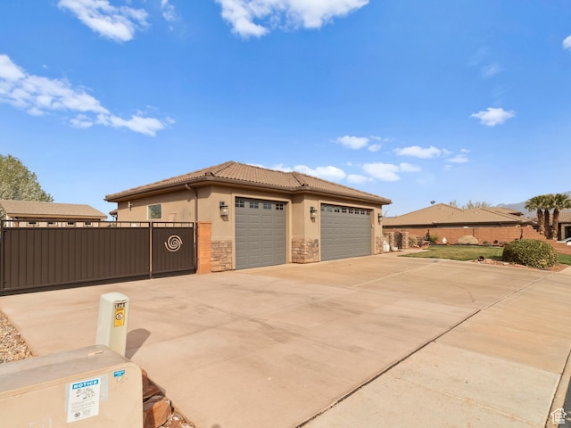 1908 S Yuma Dr, Washington, UT 84780 - view of front facade with stone siding, stucco siding, a tile roof, a garage, and driveway