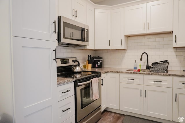 1055 S 500 E Unit D204, Heber City, UT 84032 - kitchen featuring light stone counters, a sink, white cabinetry, appliances with stainless steel finishes, and tasteful backsplash