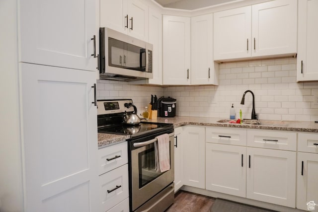 1055 S 500 E Unit D204, Heber City, UT 84032 - kitchen featuring backsplash, appliances with stainless steel finishes, white cabinetry, a sink, and light stone countertops
