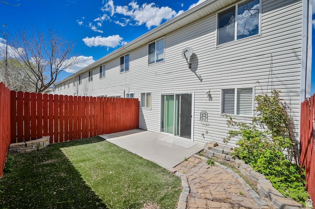 back of property featuring a patio, a yard, and fence
