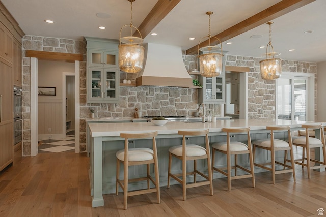 1685 W Midway Ln, Heber City, UT 84032 - kitchen with light wood-style flooring, beam ceiling, light countertops, a spacious island, and custom range hood