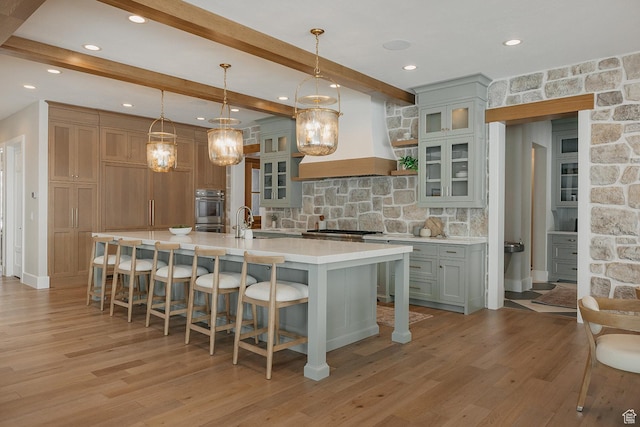 1685 W Midway Ln, Heber City, UT 84032 - kitchen with stainless steel appliances, custom exhaust hood, light countertops, decorative backsplash, and light wood-style floors