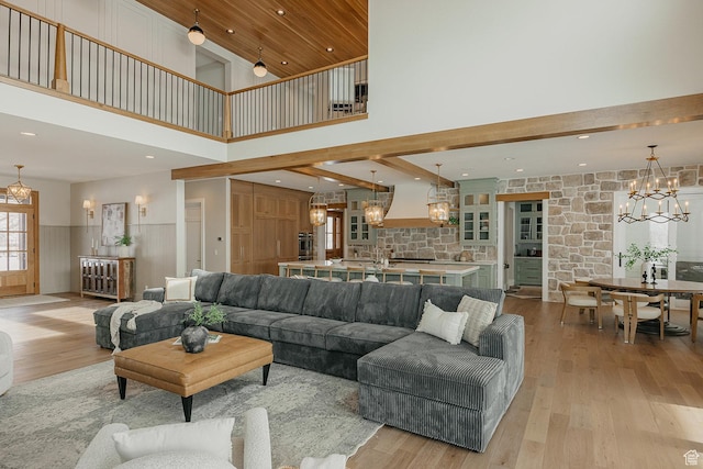 1685 W Midway Ln, Heber City, UT 84032 - living area featuring a wainscoted wall, an inviting chandelier, a towering ceiling, and light wood-type flooring