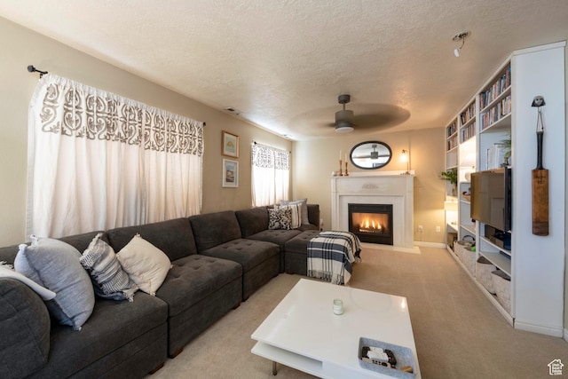 1446 E Murdock Dr S, Pleasant Grove, UT 84062 - living room featuring a textured ceiling, ceiling fan, light colored carpet, a fireplace with flush hearth, and visible vents