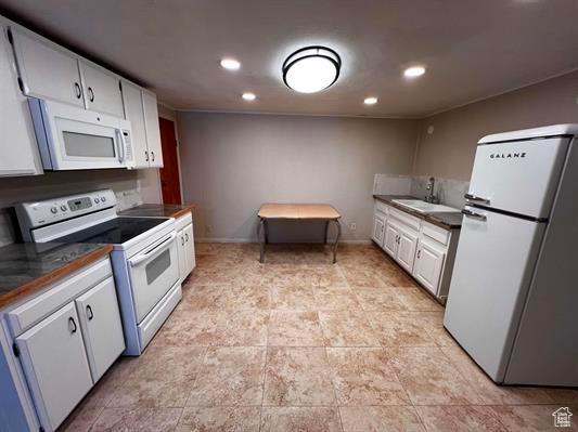 404 N 1st E, Grace, ID 83241 - kitchen featuring a sink, dark countertops, recessed lighting, and white appliances