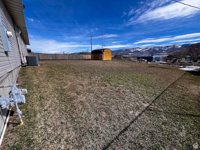 404 N 1st E, Grace, ID 83241 - view of yard with an outbuilding, central air condition unit, fence, a mountain view, and a storage shed