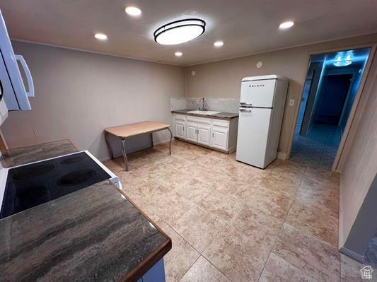 404 N 1st E, Grace, ID 83241 - kitchen with freestanding refrigerator, a sink, white cabinetry, and recessed lighting