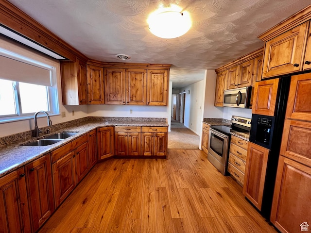404 N 1st E, Grace, ID 83241 - kitchen featuring a sink, stainless steel appliances, light wood-style floors, and brown cabinets