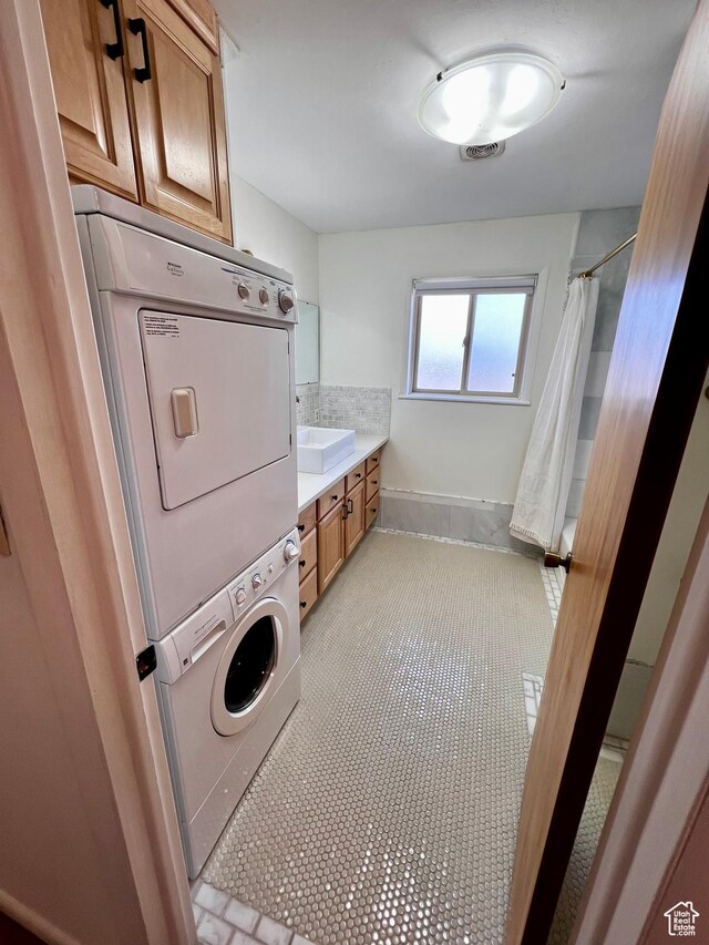 404 N 1st E, Grace, ID 83241 - clothes washing area featuring stacked washer and dryer, a sink, light tile patterned floors, visible vents, and cabinet space