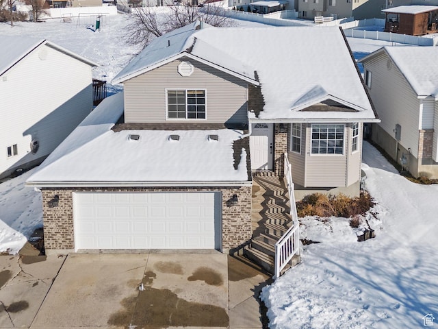 257 Rosewood Cir, Logan, UT 84321 - view of front facade featuring driveway, brick siding, and an attached garage