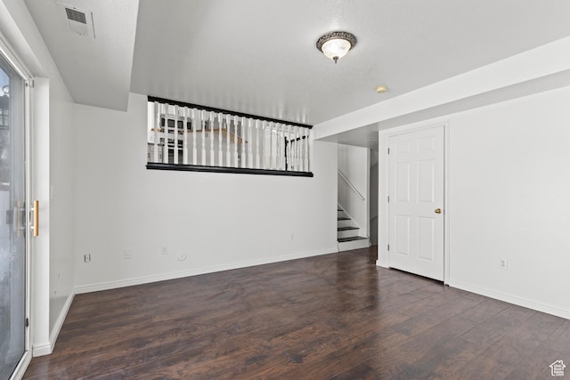 257 Rosewood Cir, Logan, UT 84321 - empty room with stairs, dark wood-type flooring, visible vents, and baseboards