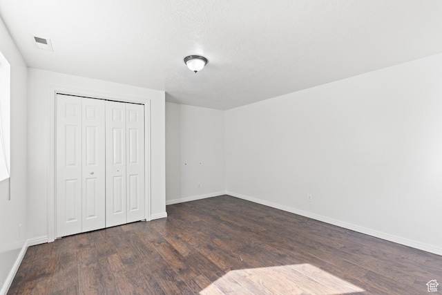 257 Rosewood Cir, Logan, UT 84321 - unfurnished bedroom featuring baseboards, a closet, visible vents, and dark wood-style flooring