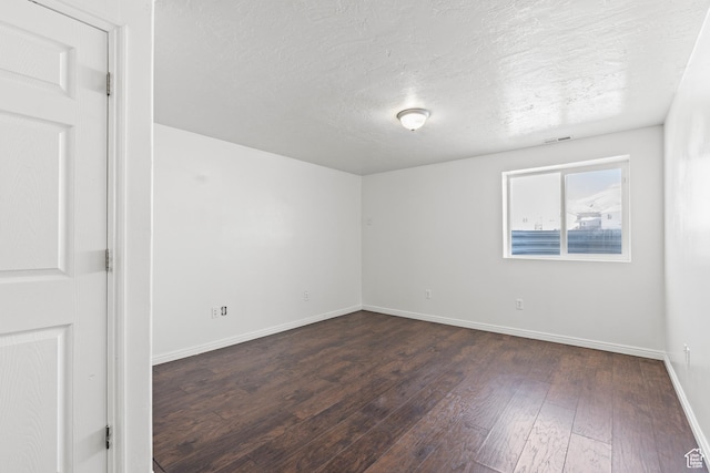257 Rosewood Cir, Logan, UT 84321 - spare room with visible vents, dark wood finished floors, a textured ceiling, and baseboards