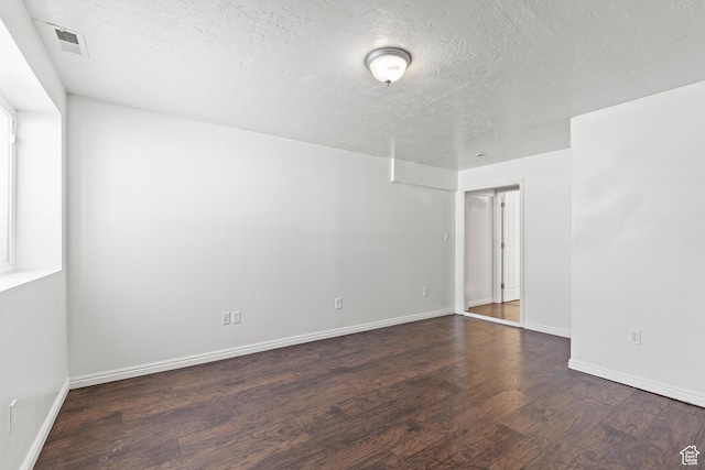 257 Rosewood Cir, Logan, UT 84321 - empty room featuring dark wood-style floors, a textured ceiling, visible vents, and baseboards