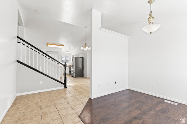 257 Rosewood Cir, Logan, UT 84321 - unfurnished room featuring stairs, light wood-style floors, visible vents, and baseboards