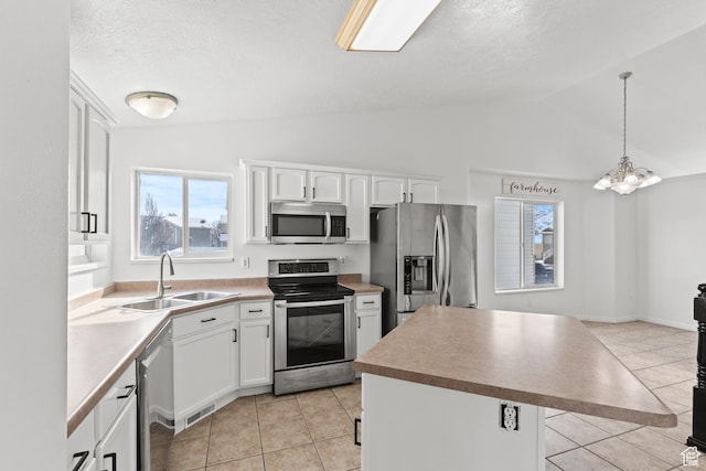 257 Rosewood Cir, Logan, UT 84321 - kitchen with white cabinets, a kitchen island, hanging light fixtures, stainless steel appliances, and a sink