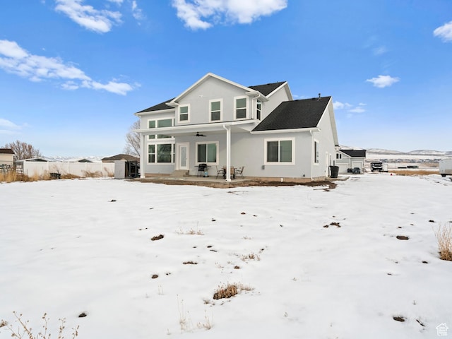 8345 W 11050 N, Tremonton, UT 84337 - snow covered property featuring stucco siding, covered porch, and a ceiling fan