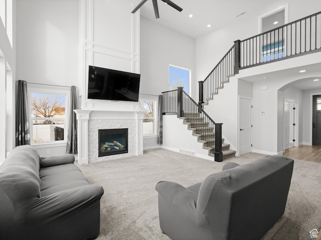 8345 W 11050 N, Tremonton, UT 84337 - living room featuring light colored carpet, arched walkways, ceiling fan, and stairway