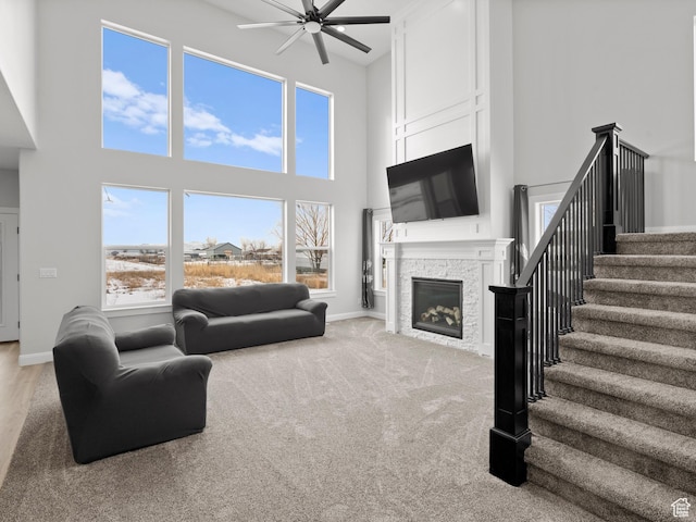 8345 W 11050 N, Tremonton, UT 84337 - carpeted living room with baseboards, stairs, ceiling fan, and a stone fireplace