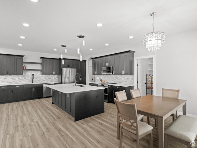 8345 W 11050 N, Tremonton, UT 84337 - kitchen with light countertops, a chandelier, stainless steel appliances, a sink, and light wood-type flooring