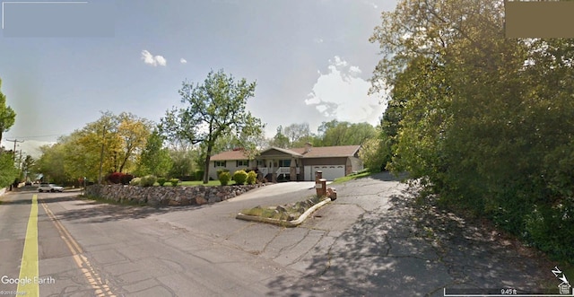 ranch-style home featuring aphalt driveway