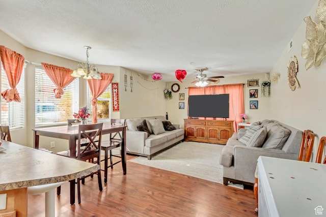 3842 S Clare Dr Unit D-1, West Valley City, UT 84119 - living room featuring light wood-type flooring, a textured ceiling, and ceiling fan with notable chandelier