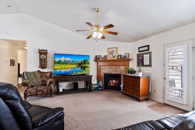 living area with lofted ceiling, ceiling fan, light carpet, and a fireplace