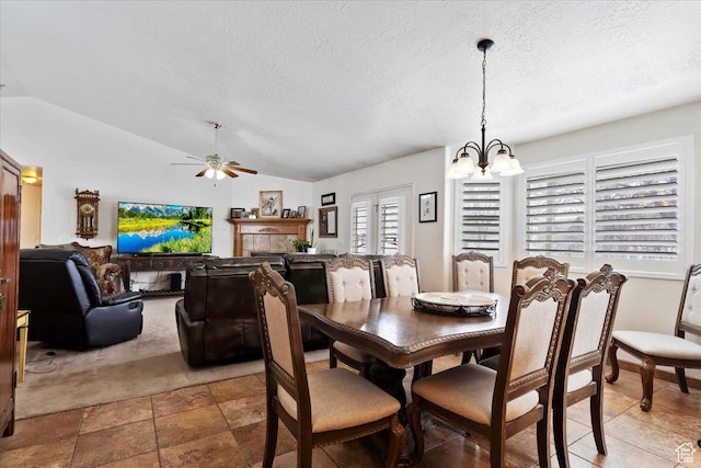 dining room featuring a chandelier, lofted ceiling, a textured ceiling, and a ceiling fan