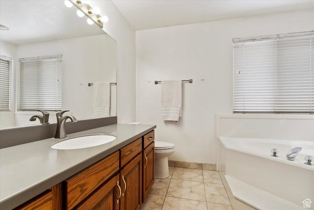 bathroom with vanity, a bath, toilet, and baseboards