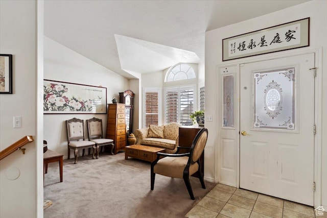 entrance foyer featuring vaulted ceiling, light colored carpet, and light tile patterned floors