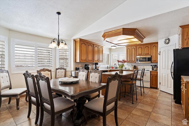 dining room featuring a textured ceiling, a chandelier, lofted ceiling, and light tile patterned floors