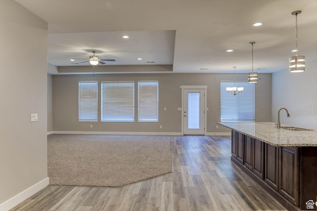 4386 W 3800 S, West Haven, UT 84401 - kitchen featuring light stone counters, open floor plan, dark brown cabinetry, a sink, and baseboards