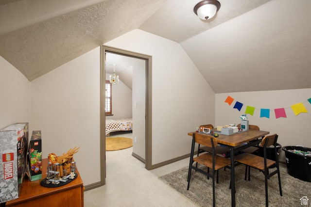 dining area featuring a textured ceiling, baseboards, lofted ceiling, and light colored carpet